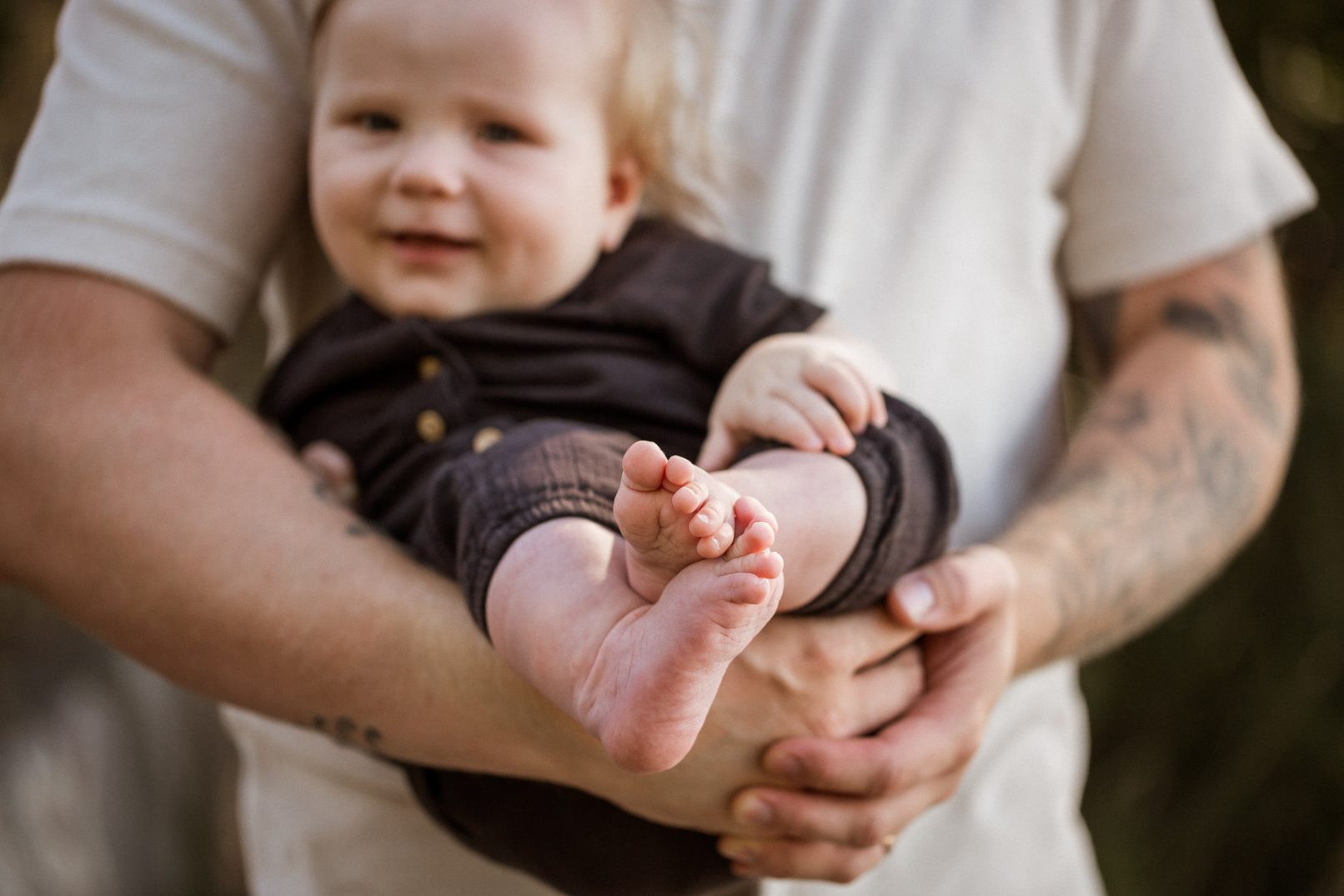 Vauva isän sylissä, paljaat varpaat. Perhekuvaus Helsinki - Siru Danielsson Photography